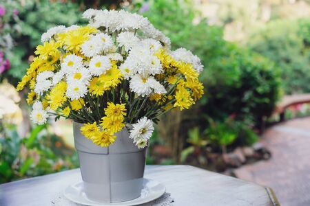Beautiful yellow and white flowers on tableの写真素材