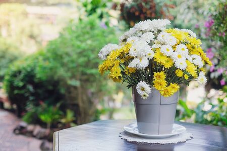 Beautiful yellow and white flowers on tableの写真素材