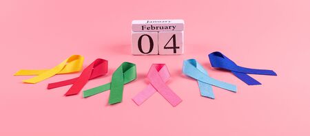 World cancer day (February 4). colorful awareness ribbons; blue, red, green, pink and yellow color on wooden background for supporting people living and illness. Healthcare and medicine conceptの写真素材