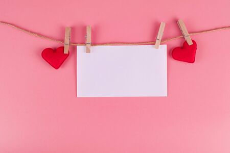 Red heart shape decoration hanging on line with copy space for text on pink background. Love, Wedding, Romantic and Happy Valentine day holiday conceptの写真素材