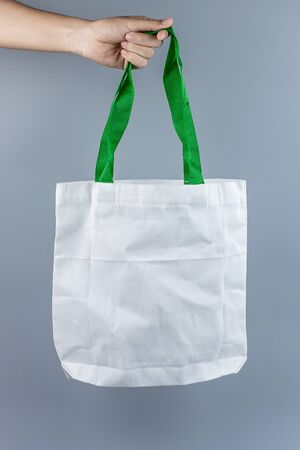 Man holding Eco Shopping bag on gray background with Copy space for text. Environmental Protection, Zero waste, Reusable, Say No Plastic, World Environment day and Earth day conceptの写真素材
