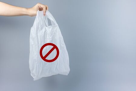 Man holding plastic bag against gray background with Copy space for text. Environmental Protection, Zero waste, Reusable, Say No Plastic, World Environment day and Earth day conceptの写真素材