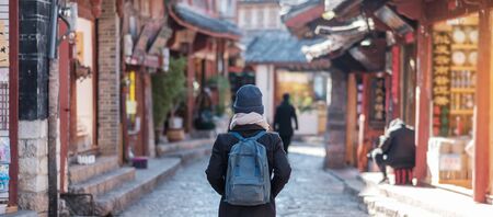 young woman traveler traveling at the Square street in Lijiang Old Town, landmark and popular spot for tourists attractions in Lijiang, Yunnan, China. Asia travel conceptの写真素材
