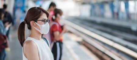young Asian woman wearing protection mask against Novel coronavirus (2019-nCoV) at public train...