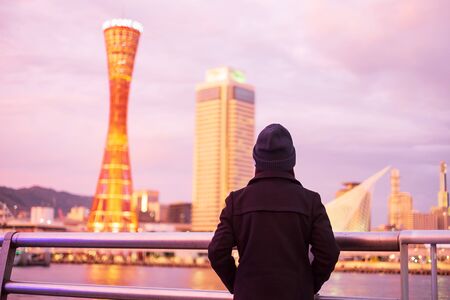 Young woman traveling at Kobe port near Osaka, Happy Asian traveler looking beautiful modern buildings at sunset. landmark and popular for tourist attractions in Kobe, Hyogo, Japan.Asia Travel conceptの写真素材