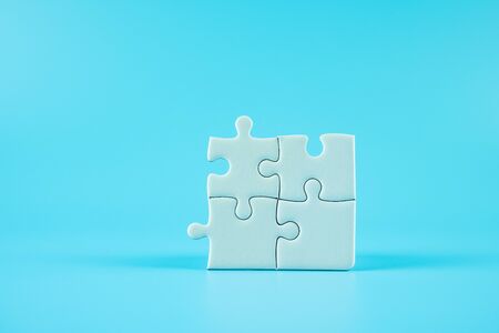 Jigsaw puzzle pieces on blue background with copy space for text. solutions, mission, successful, goals, cooperation, partnership and strategy conceptの写真素材