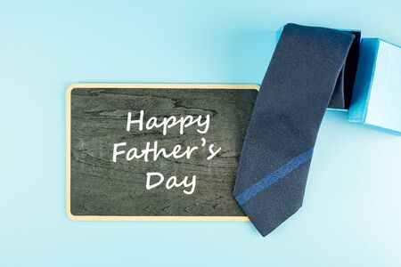 blue necktie and gift box on blue background. Happy Father's Day and International Men's Day conceptsの写真素材