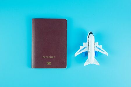 Top view passport and  airplane model on blue background with copy space for textの写真素材