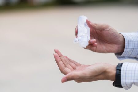 man hands using wash hand sanitizer gel dispenser, against Novel coronavirus or Corona Virus Disease (Covid-19) at public train station. Antiseptic, Hygiene and Healthcare conceptの写真素材