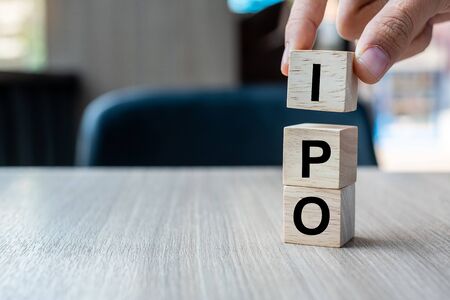 Businessman hand holding IPO (Initial Public Offering) word with wooden cube block, shares of a private corporation to the public in a new stock issuance. Stock, Fund, Investors and Investment conceptの写真素材