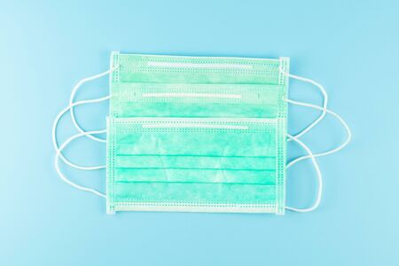 Surgical face mask on blue background, against Novel coronavirus or Corona Virus Disease (Covid-19). Antiseptic, Hygiene and Healthcare conceptの写真素材