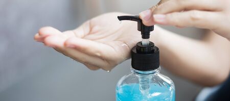 Woman hands using wash hand sanitizer gel dispenser, against Novel coronavirus or Corona Virus Disease (Covid-19) at public train station. Antiseptic, Hygiene and Healthcare conceptの写真素材