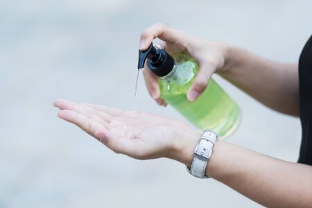 Woman hands using wash hand sanitizer gel dispenser, against Novel coronavirus or Corona Virus Disease (Covid-19) at public Indoor. Antiseptic, Hygiene and Healthcare conceptの写真素材
