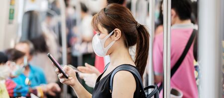 young Asian woman wearing surgical face mask against Novel coronavirus or Corona Virus Disease (Covid-19) at subway inside. Hygiene, Healthcare and infection conceptの写真素材