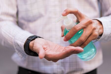 man hand using wash hand sanitizer gel dispenser, against Novel coronavirus or Corona Virus Disease (Covid-19) at public Indoor. Antiseptic, Hygiene and Healthcare conceptの写真素材