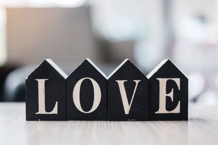 Love text with wooden Home model  on table office. New House, Financial, Property, Happy Valentines day and real estate conceptsの写真素材