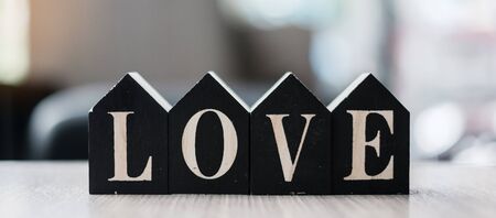 Love text with wooden Home model  on table office. New House, Financial, Property, Happy Valentines day and real estate conceptsの写真素材
