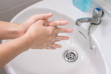 Woman Washing hands with liquid soap Step 3: Interlink your fingers, against Novel coronavirus or Corona Virus Disease (Covid-19). Antiseptic, personal Hygiene and Healthcare conceptの写真素材