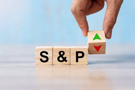 business man Hand change wood cube block with S&P text to UP and Down arrow symbol icon. Interest rate, stocks, financial, ranking, mortgage rates and Cut loss conceptの写真素材