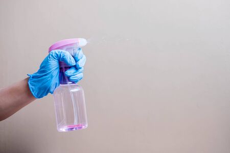 Man spraying disinfectant bottle, prevent coronavirus or Corona Virus Disease (Covid-19) at office or home. Antivirus, personal Hygiene, New normal and Health conceptの写真素材