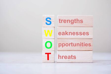 SWOT text wooden cube with Strengths, Weakness, Opportunity and Threats blocks on table background. Business and analysis conceptの写真素材