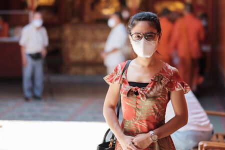 young Asian girl wearing Protective face mask protect coronavirus inflection, Happy tourist woman in New Normal lifestyle after covid-19 pandemicの写真素材