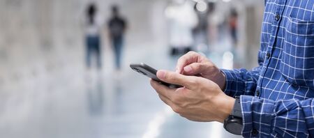 Young casual Businessman holding and using smartphone for sms messages, tourist man typing...