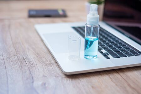 alcohol spray sanitizer and computer laptop on workplace at home office, protection coronavirus (Covid-19) infection. New Normal and personal hygiene conceptの写真素材
