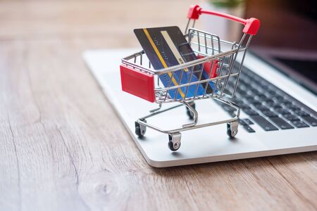 Shopping cart and credit card on laptop at home office. business, e-business, technology, e-commerce, digital banking and online payment conceptの写真素材