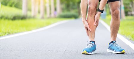 Young adult male with his muscle pain during running. runner man having leg ache due to Shin Splints. Sports injuries and medical conceptの写真素材