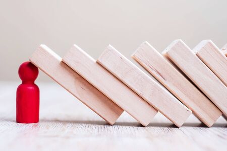 Red wooden Man stop falling blocks on table. fall Business, planning, Management, Leader, Insurance, teamwork and strategy Conceptsの写真素材