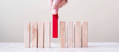 Businessman hand placing or pulling Red wooden block on table. Business planning, Risk Management, Solution, leader, strategy, different and Unique Conceptsの写真素材