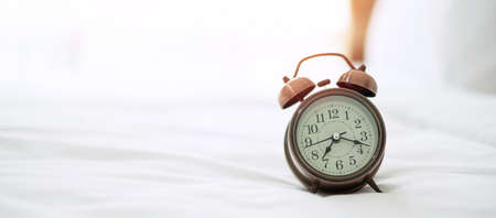 Retro alarm clock on bed in the morning sunlight, wake up, fresh relax, have a nice day and daily...