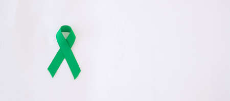 green Ribbon for supporting people living and illness. Liver, Gallbladders bile duct, kidney Cancer and Lymphoma Awareness month conceptの写真素材