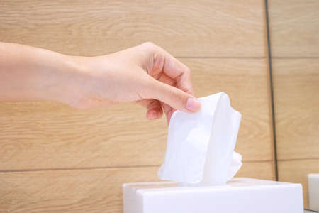 Woman hand pulling toilet paper in restroom. Cleaning, Lifestyle and personal hygiene concept