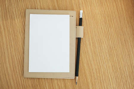 blank notebook with pencil on wooden table background. top view and copy space for your textの写真素材
