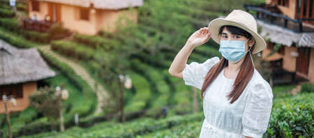Happy tourist woman wearing surgical face mask  enjoy beautiful Tea garden, protection Coronavirus...