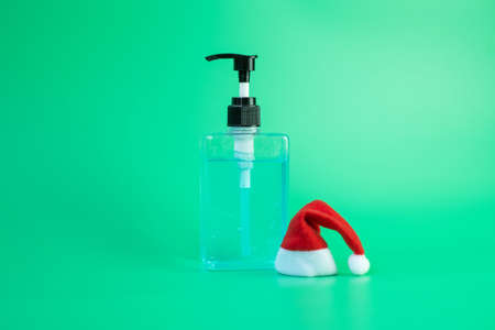 Merry Christmas with Santa Clause hat and wash hand sanitizer gel bottle against coronavirus or Corona Virus Disease (Covid-19). Holiday, Hygiene, New Normal and Healthcare conceptの写真素材