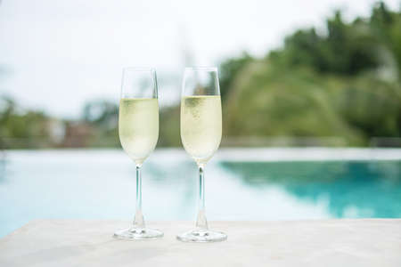 Two sparkling champagne glasses or prosecco near swimming pool. Summer travel, vacation, holiday and weekend conceptの写真素材