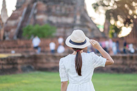 Tourist Woman in white dress visiting to ancient stupa in Wat Chaiwatthanaram temple in Ayutthaya Historical Park, summer, Asia and Thailand travel conceptの写真素材