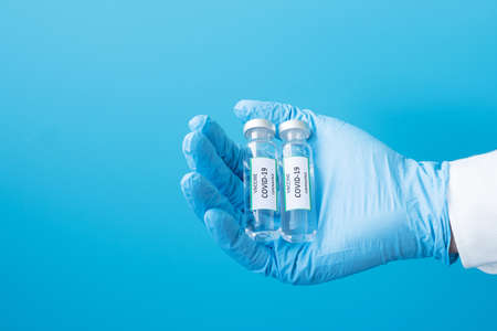COVID-19 Vaccine vial against Coronavirus infection in hand of doctor with Nitrile Glove in hospital...