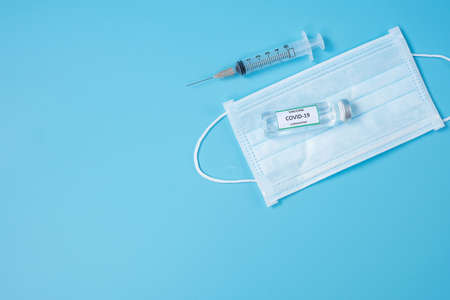 COVID-19 Vaccine vial, injection Needle Syringe and Face mask against Coronavirus infection in hospital laboratory. Medical, health, Vaccination and immunization conceptの写真素材