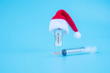 COVID-19 Vaccine vial, injection Needle Syringe and Santa Clause hat against Coronavirus infection in hospital laboratory. Christmas, New Year, Medical, health, Vaccination and immunization conceptの写真素材