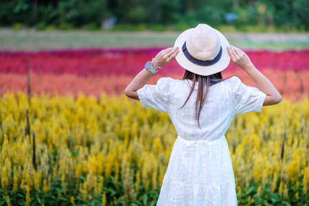 Happy tourist woman in white dress enjoy beautiful Flowers garden. travel, nature, vacation and holiday conceptの写真素材