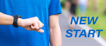 New Start with Young man checking time and cardio heart rate on sport smartwatch during running in...