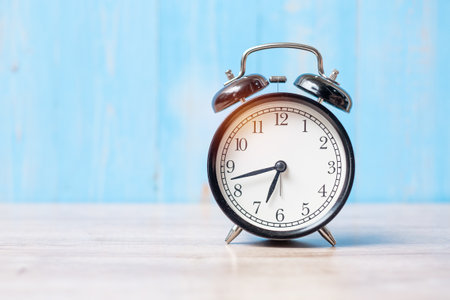alarm clock on wooden table background and copy space for text. Activity, morning, workout and Work life balance conceptの写真素材