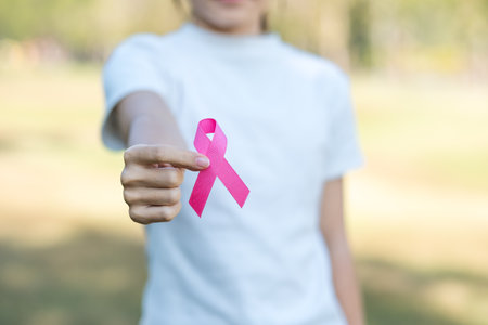 October Breast Cancer Awareness month, adult Woman hand holding Pink Ribbon for supporting people living and illness. International Women, Mother and World cancer day conceptの写真素材