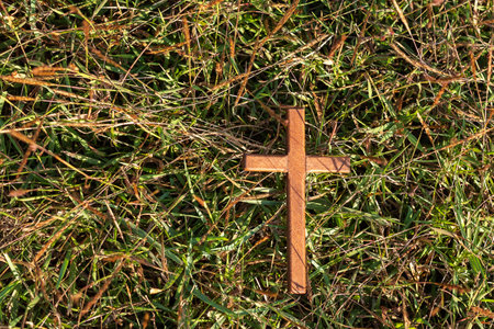 wood cross on grass, pray for blessings from God. Christian Religion, Crucifix and Faith conceptの写真素材