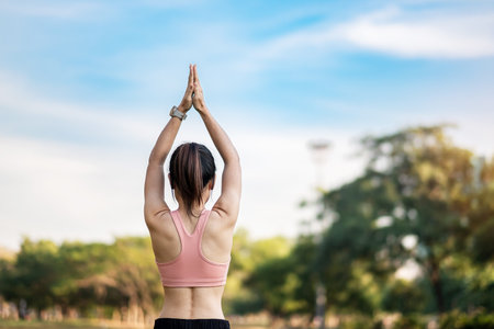 Young adult female in pink sportswear stretching muscle in the park outdoor, sport woman warm up ready for running and jogging in morning. wellness, fitness, exercise and work life balance conceptsの写真素材