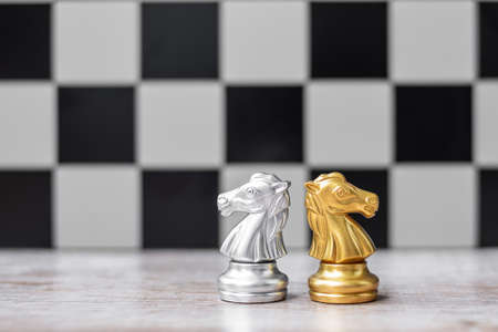 Gold and silver Chess Knight (horse) figure with businessman manager background. Strategy, Conflict, management, business planning, tactic, politic, communication and leader conceptの写真素材